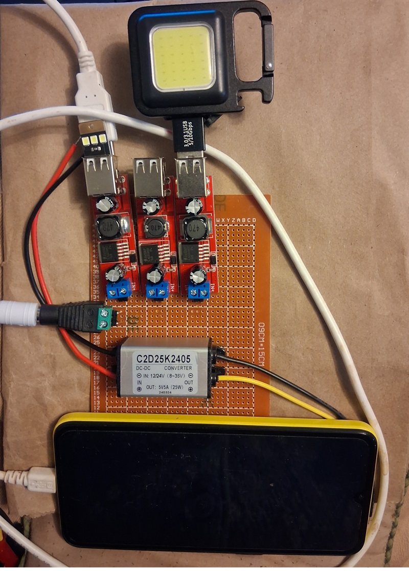 Early USB charging prototype with rechargeable work light and cell phone